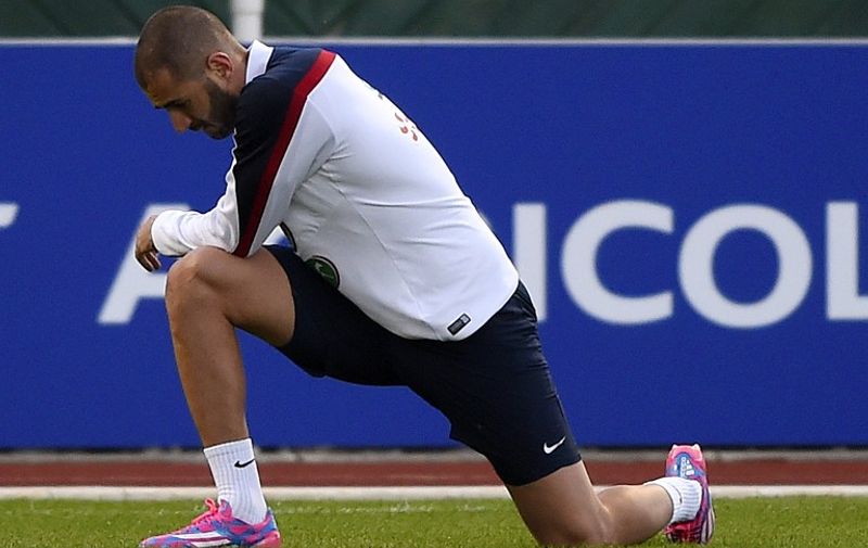 French forward Karim Benzema strectches after an injury during a training session in Clairefontaine-en-Yvelines on October 7, 2014 ahead of a friendly football match against Portugal to be held on October 11, 2014 at the Stade de France in Saint-Denis, outside Paris. AFP PHOTO / FRANCK FIFE