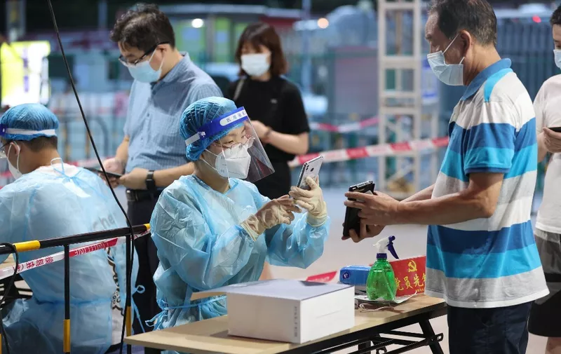 This photo taken on August 10, 2022 shows a medical worker checking information before a nucleic acid test for the Covid-19 coronavirus at a swab collection site in Xiamen, in China's eastern Fujian province. (Photo by AFP) / China OUT