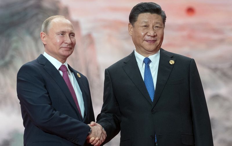 Russian President Vladimir Putin (l) shakes hands with President of the Peoples Republic of China Xi Jinping during a welcoming ceremony at the Shanghai Cooperation Organization (SCO) Council of Heads of State in Qingdao on June 10, 2018. (Photo by Sergei GUNEYEV / Sputnik / AFP)