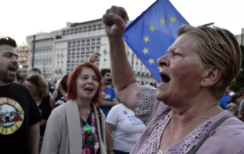 Pro-European Union protesters shout slogan and wave EU flags in front of the Greek parliament in Athens on July 9, 2015. Greece was to submit a detailed bailout request to its eurozone partners on July 9 in a last-ditch effort to save its collapsing economy and its place in the euro, in an unprecedented test of EU cohesion. With the crisis reaching a climax that could have unpredictable consequences, the EU president urged creditors to compromise on granting debt relief to Greece. AFP PHOTO/ LOUISA GOULIAMAKI
- FRANCE OUT -