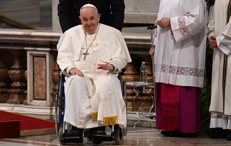 Pope Francis, seated in his wheelchair, leaves after presiding over the celebration of Chrism Mass, as part of the Holy Week, on April 6, 2023 at St. Peter's basilica in The Vatican. (Photo by Andreas SOLARO / AFP)