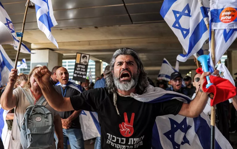 Anti-government protesters march at Israel's Ben Gurion Airport near Lod on July 3, 2023. (Photo by JACK GUEZ / AFP)