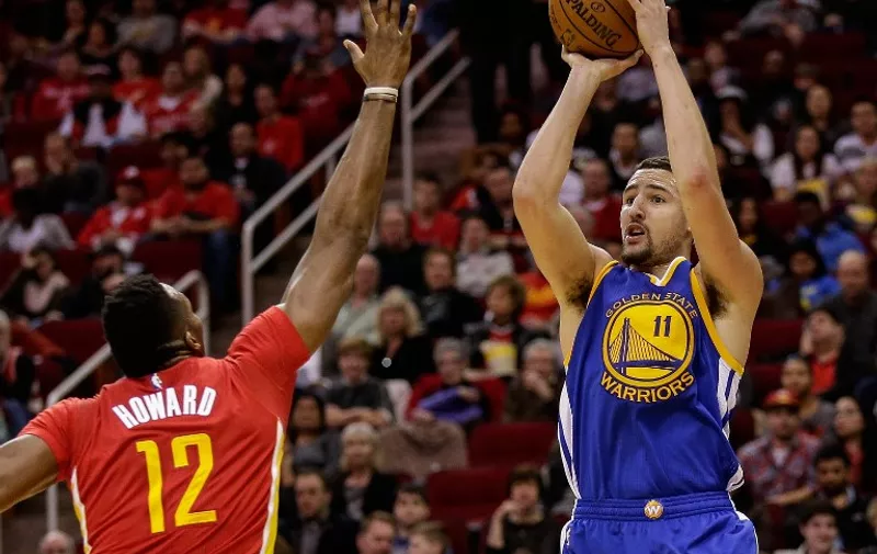 HOUSTON, TX - DECEMBER 31: Klay Thompson #11 of the Golden State Warriors shoots ocer the outstretched arm of Dwight Howard #12 of the Houston Rockets in the second half at Toyota Center on December 31, 2015 in Houston, Texas. NOTE TO USER: User expressly acknowledges and agrees that, by downloading and or using this Photograph, User is consenting to the terms and conditions of the Getty Images License Agreement. Mandatory Copyright Notice: Copyright 2015 NBAE   Bob Levey/Getty Images/AFP