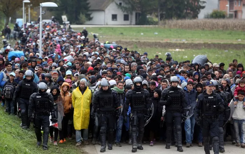 TOPSHOTS
About 1000 migrants are escorted by Slovenian police officers from the border crossing with Croatia, on October 22, 2015, near the village Rigonce to Dobova in Slovenia. More than 12,600 migrants arrived in Slovenia over a 24-hour period, police said on October 22, 2015, a record that surpasses even that in Hungary at the height of the crisis in September. AFP PHOTO / STRINGER