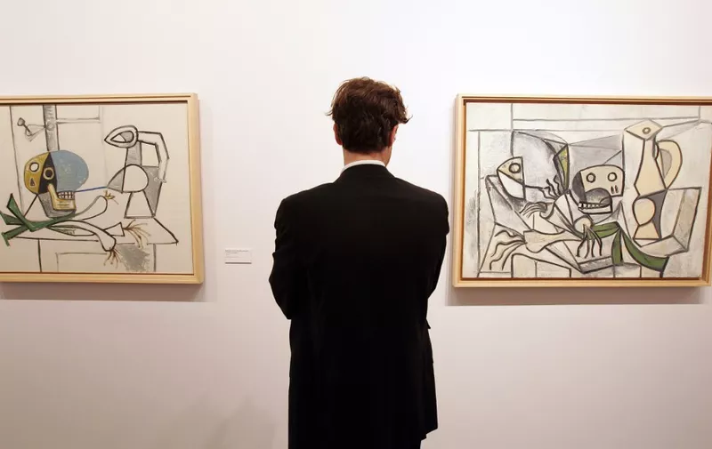 A visitor looks at "Nature morte a la tete de mort cruche, poireaux" (L) and "Nature morte aux poireaux tete de poisson, crane et pichet" by painter Pablo Picasso on display at the Palazzo Grassi in Venice 09 November 2006 as part of the "Picasso, la joie de vivre, 1945-1948" exhibition. The exhibition is dedicated to a four year period in Picasso's life, in the immediate postwar. Some 200 of Picasso's works are on display, including paintings, drawings, marble incisions, sculptures, and pottery. Numerous works belonging to private and public collections and 120 masterpieces from The Picasso Museum collection in Antibes. The exhibition. will be open to the pubblic  from 11 November 2006 to 11 March 2007.    AFP PHOTO / ALBERTO PIZZOLI (Photo by ALBERTO PIZZOLI / AFP)