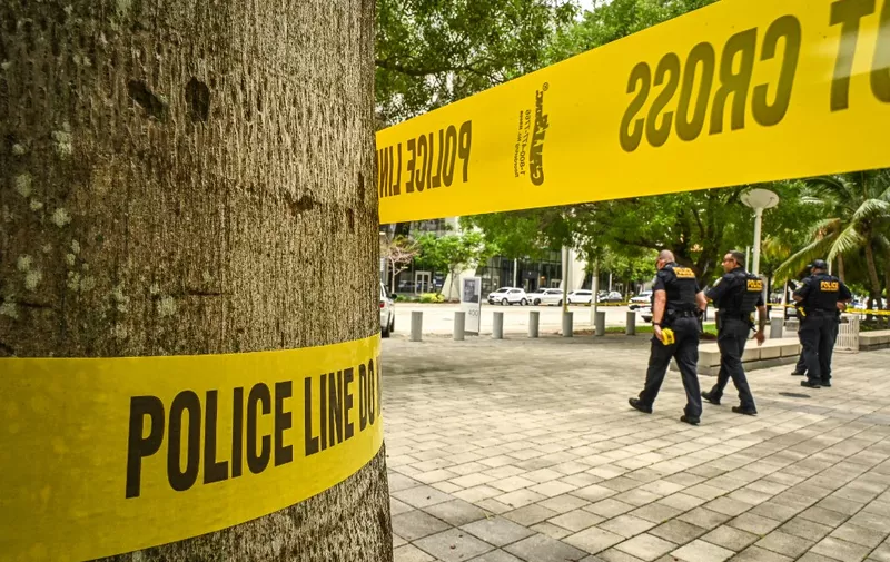 Law enforcement officers are seen walking past police tape in front of the Wilkie D. Ferguson Jr. United States Federal Courthouse in Miami, Florida, on June 12, 2023. Trump is expected to appear in court in Miami on June 13 for an arraignment regarding 37 federal charges, including violations of the Espionage Act, making false statements, and conspiracy regarding his mishandling of classified material after leaving office. (Photo by Giorgio Viera / AFP)