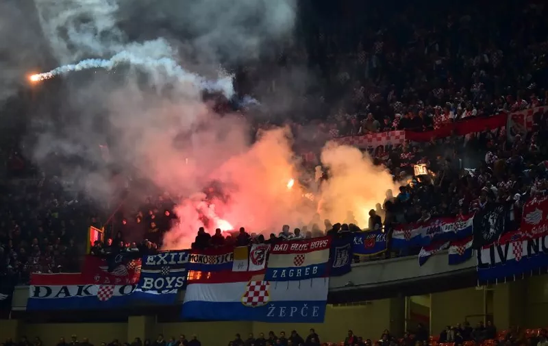 Croatia's supporters throw flares on the pitch during the Euro 2016 qualifying football match Italy vs Croatia on November 16, 2014 at the San Siro stadium in Milan.   AFP PHOTO / GIUSEPPE CACACE