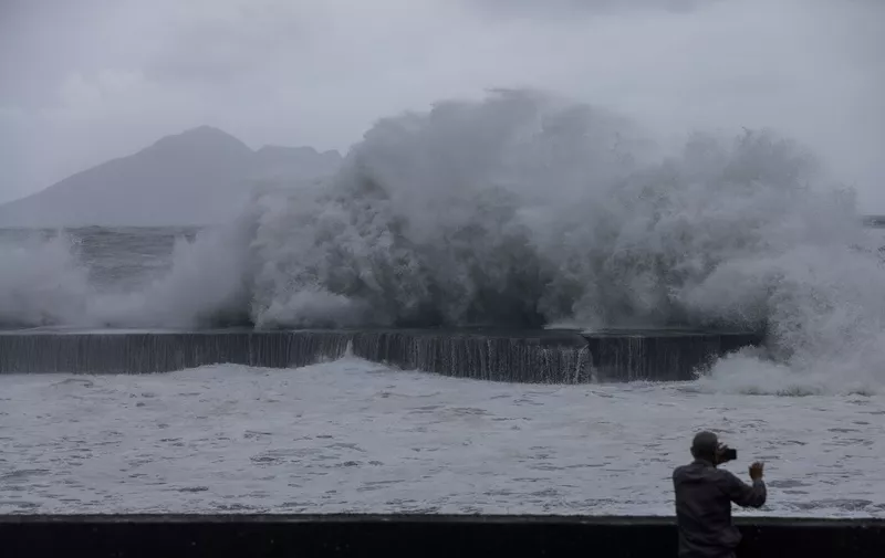 A man takes pictures of huge waves in Yilan as Typhoon Haikui makes landfall in eastern Taiwan on September 3, 2023. (Photo by I-Hwa Cheng / AFP)