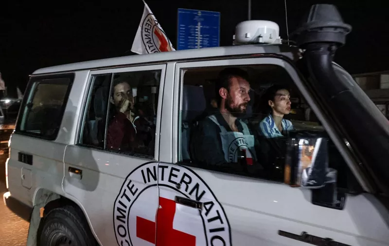 An International Red Cross vehicle carrying Israeli Russian hostage Ron Krivoy released by Hamas drives towards the Rafah border point with Egypt ahead of a transfer to Israel on November 26, 2023. The Israeli army said in a statement on November 26, 2023 that 13 released hostages were back on Israeli territory, and another four were on their way via the Rafah crossing between the Gaza Strip and Egypt. (Photo by Mohammed ABED / AFP)