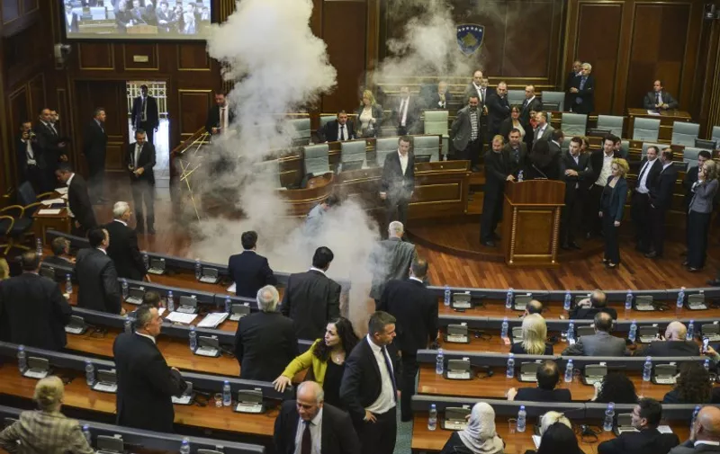 Parliamentarians disperse as a white cloud of tear gas rises after being released by opposition lawmakers in Kosovo's parliament in Pristina on October 15, 2015, for the second time in a week. Opposition MPs in Kosovo on October 15 disrupted a parliamentary session by releasing tear gas into the chamber for the second week running, in protest at agreements made with Serbia. The protesters are angry at EU-brokered dialogue and agreements with Serbia, particularly a plan to set up an association of Serb-run municipalities giving Kosovo's Serb minority greater autonomy. AFP PHOTO / DRITON VITIA