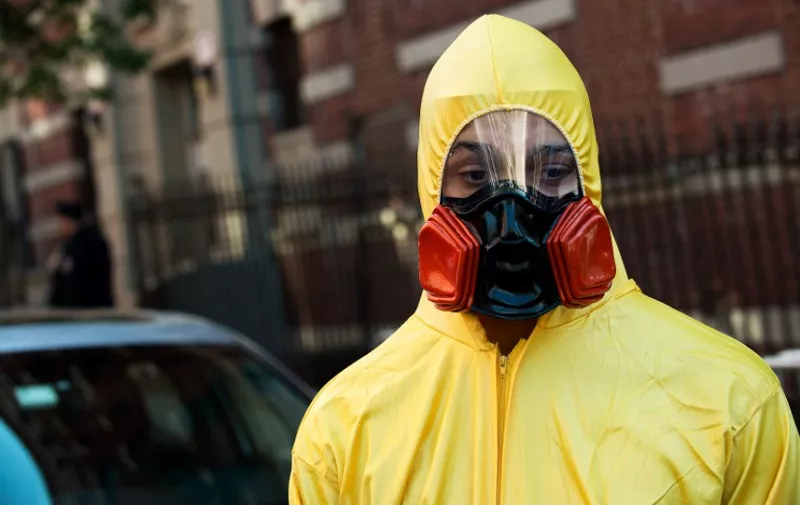 NEW YORK, NY - OCTOBER 25: A young man, dressed in a biohazard costume, stands on the corner of 546 West 147th Street on October 25, 2014 in New York City. After returning to New York City from Guinea, where he was working with Doctors Without Borders treating Ebola patients, Dr. Craig Spencer was quarantined after showing symptoms consistent with the virus. Spencer was taken to Bellevue hospital to undergo testing where he was officially diagnosed with the Ebola virus on October 23.   Bryan Thomas/Getty Images/AFP