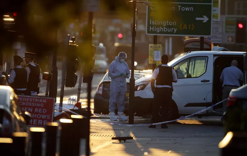 Forensic investigators work the scene in the Finsbury Park area of north London after a vehichle hit pedestrians, on June 19, 2017. 
One man was killed and eight people hospitalised when a van ran into pedestrians near a mosque in north London in an incident that is being investigated by counter-terrorism officers, police said on Monday. The 48-year-old male driver of the van "was found detained by members of the public at the scene and then arrested by police," a police statement said.
 / AFP PHOTO / Daniel LEAL-OLIVAS