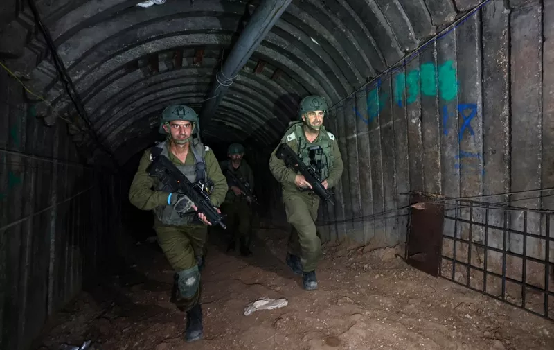 In this picture taken during a media tour organised by the Israeli military on December 15, 2023, soldiers visit a tunnel that Hamas reportedly used to attack Israel through the Erez border crossing on October 7. The Israeli army said on December 17, 2023 it had uncovered the biggest Hamas tunnel in the Gaza Strip so far, just a few hundred metres from the Erez border crossing. (Photo by JACK GUEZ / AFP)