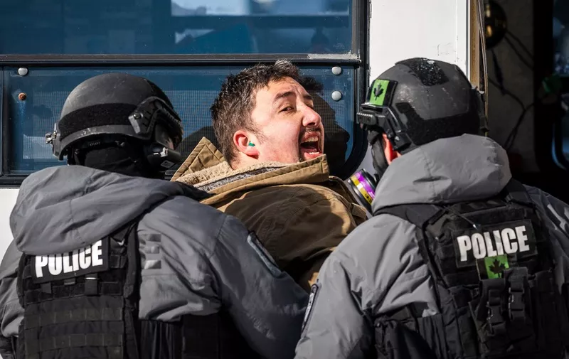 Police arrest a demonstrator against Covid-19 mandates in Ottawa on February 18, 2022. - Canadian police on Thursday began a massive operation to clear the trucker-led protests against Covid health rules clogging the capital for three weeks, with several arrests made. (Photo by ANDREJ IVANOV / AFP)