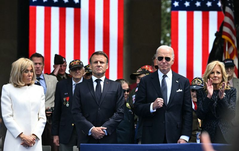 US President Joe Biden (C), US First Lady Jill Biden (R), France's President Emmanuel Macron (2nd L) and French President's wife Brigitte Macron (L) attend the US ceremony marking the 80th anniversary of the World War II "D-Day" Allied landings in Normandy, at the Normandy American Cemetery and Memorial in Colleville-sur-Mer, which overlooks Omaha Beach in northwestern France, on June 6, 2024. The D-Day ceremonies on June 6 this year mark the 80th anniversary since the launch of 'Operation Overlord', a vast military operation by Allied forces in Normandy, which turned the tide of World War II, eventually leading to the liberation of occupied France and the end of the war against Nazi Germany. (Photo by SAUL LOEB / AFP)