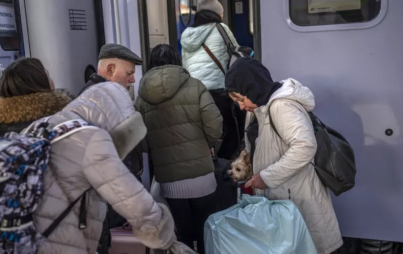 Ukrainian refugees board a train en route to Warsaw at the railway station in Przemysl, near the Polish-Ukrainian border, on March 27, 2022, following Russia's invasion of Ukraine about one month ago. - More than 3.8 million people have fled Ukraine since Russia's invasion a month ago, UN figures showed on March 27, 2022, but the flow of refugees has slowed down markedly. The UN refugee agency, UNHCR, said 3,821,049 Ukrainians had fled the country -- an increase of 48,450 from the figures on March 26. Around 90 percent of them are women and children, it added. (Photo by Angelos Tzortzinis / AFP)