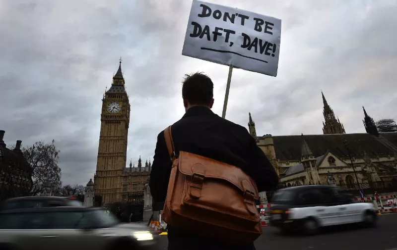 A lone protester opposed to British military action in Syria holds a placard reading 'Don't be daft, Dave!' outside the Houses of Parliament in London on December 1, 2015. Britain looks poised to join air strikes on Islamic State (IS) group targets in Syria this week after Prime Minister David Cameron announced yesterday that a vote would be held in parliament on Wednesday.
AFP PHOTO / BEN STANSALL / AFP / BEN STANSALL