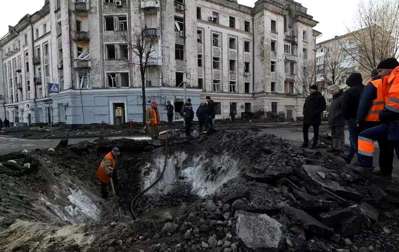 Ukranian municipal services workers survey and repair the damage following a missile attack in Kyiv, on March 21, 2024, amid the Russian invasion of Ukraine. (Photo by Sergei CHUZAVKOV / AFP)