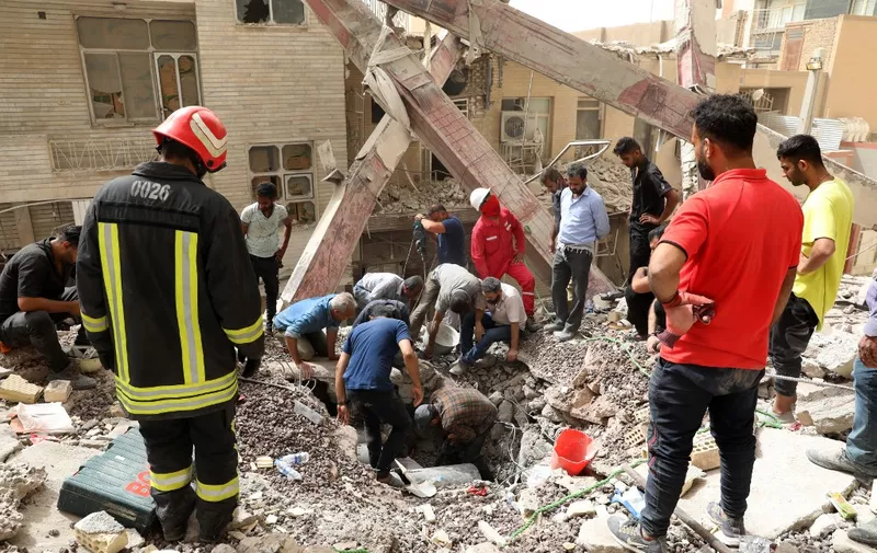 Iranians rescuers scour the rubble at the site where a ten-storey building collapsed, as rescue operations continue in the southwestern city of Abadan on May 24, 2022. - At least six people died and dozens were injured or missing under rubble after an unfinished high-rise building collapsed in southwestern Iran, officials said. (Photo by TASNIM NEWS / AFP)