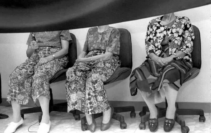 Three former "comfort women," forced or tricked into prostitution by the Japanese military government during World War II, attend a press conference 13 August 1992, their faces hidden behind a black curtain to preserve their anonymity. The women recounted their wartime ordeal.