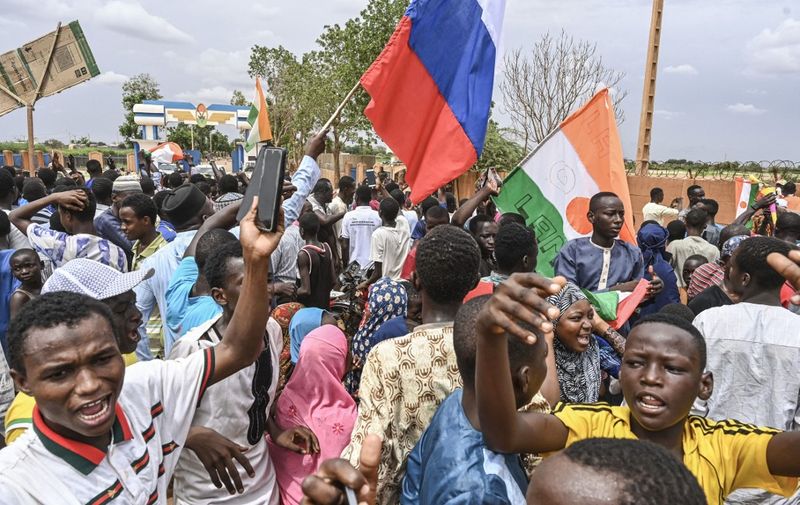 Supporters of Niger's National Council for the Safeguard of the Homeland (CNSP) hold a Russian flag as they gather for a demonstration in Niamey on August 11, 2023 near a French airbase in Niger. Thousands of supporters of Niger's coup leaders gathered on August 11, 2023 near a French military base on the outskirts of the capital Niamey. Protesters shouted "down with France, down with ECOWAS", a reference to the West African bloc which on Thursday approved deployment of a "standby force to restore constitutional order" in Niger. (Photo by AFP)