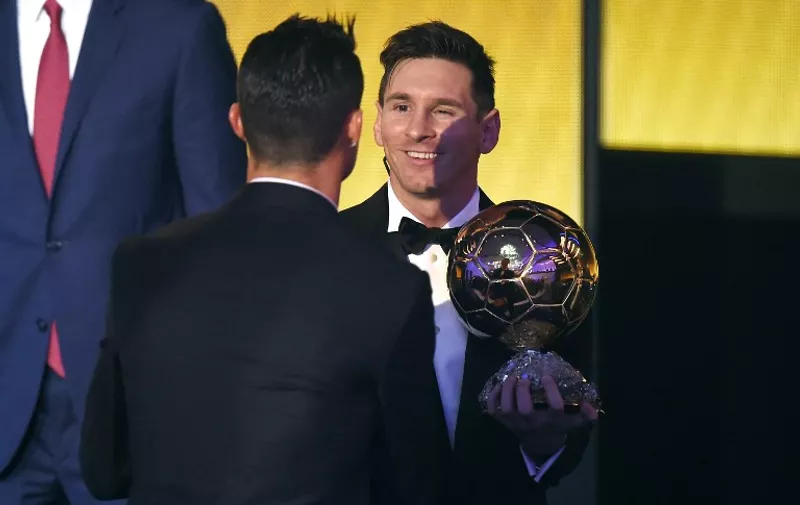 FC Barcelona and Argentina's forward Lionel Messi (R) holds his trophy as he shakes hands with Real Madrid and Portugal's forward  Cristiano Ronaldo (L) after receiving the 2015 FIFA Ballon dOr award for player of the year during the 2015 FIFA Ballon d'Or award ceremony at the Kongresshaus in Zurich on January 11, 2016. AFP PHOTO / OLIVIER MORIN / AFP / OLIVIER MORIN