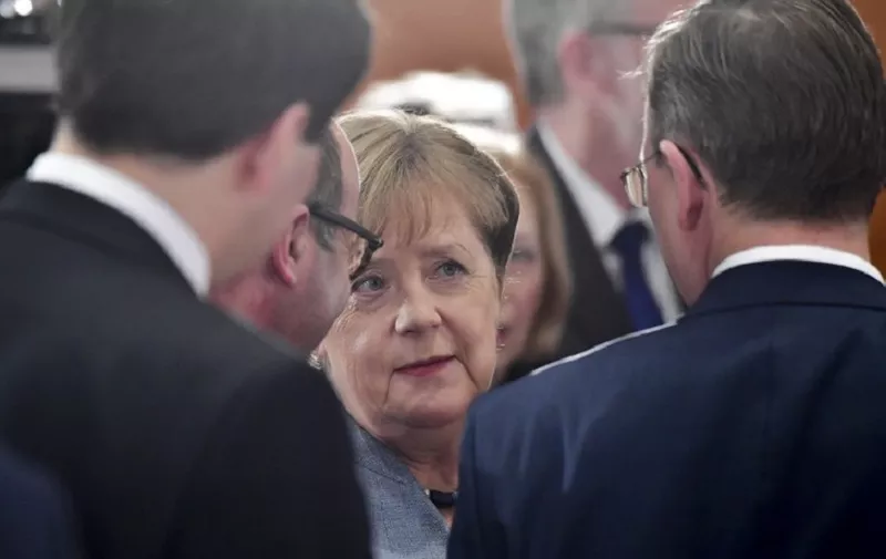 German Chancellor Angela Merkel (C) greets regional state leaders ahead before their meeting part of regular consultations on February 1, 2018 at the Chancellery in Berlin.   / AFP PHOTO / John MACDOUGALL