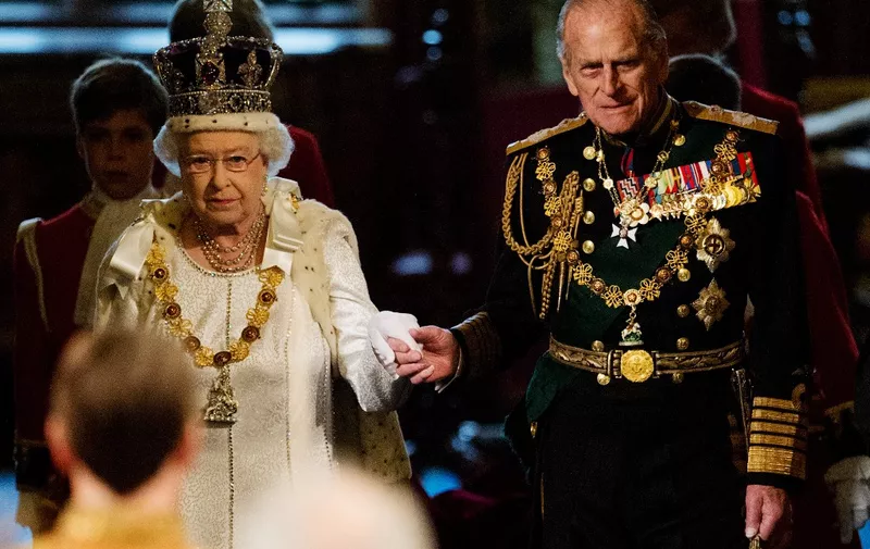 (FILES) In this file photo taken on May 09, 2012 Britain's Queen Elizabeth II (L) and Prince Philip, Duke of Edinburgh, proceed through the Royal Gallery in the Palace of Westminster, home to the Houses of Parliament, in London on May 9, 2012 during the State Opening of Parliament. - Queen Elizabeth II's 99-year-old husband Prince Philip, who was recently hospitalised and underwent a successful heart procedure, died on April 9, 2021, Buckingham Palace announced. (Photo by Leon NEAL / POOL / AFP)