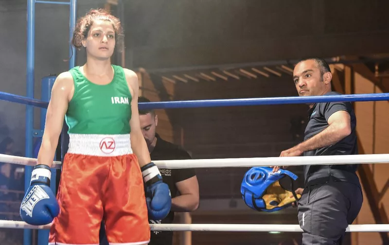 Iran's Sadaf Khadem (L) stands on the ring next to combat organiser Mahyar Monshipour (R), an Iranian-born former super bantamweight world champion, at the end of her amateur 3 rounds boxing match against France's Anne Chauvin (R) on April 13, 2019 in Royan, western France. - Sadaf Khadem became today the first Iranian woman to contest an official boxing fight. (Photo by MEHDI FEDOUACH / AFP)