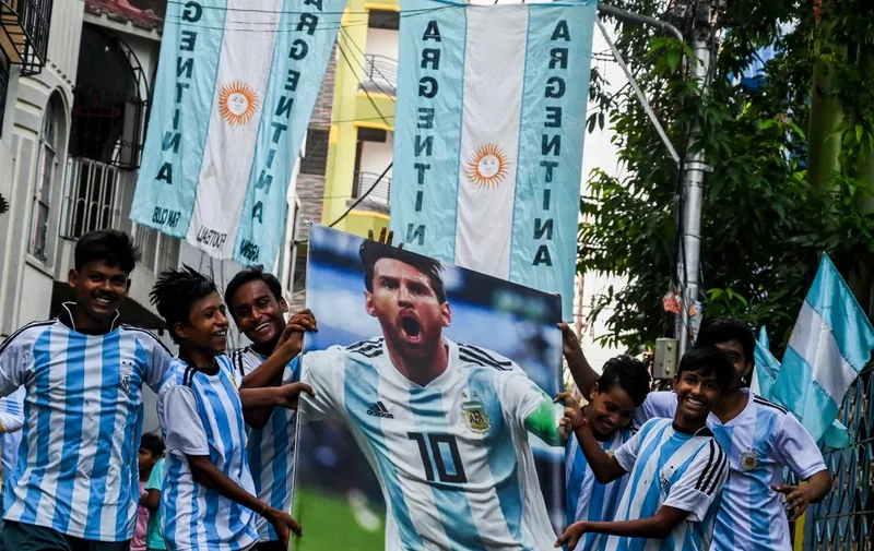 Youth carry a poster bearing a photograph of Argentine footballer Lionel Messi as they celebrate his birthday at a football fan club in Kolkata on June 24, 2022. (Photo by DIBYANGSHU SARKAR / AFP)