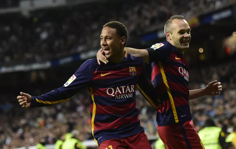 Barcelona's Brazilian forward Neymar (L) celebrates after scoring with Barcelona's midfielder Andres Iniesta during the Spanish league "Clasico" football match Real Madrid CF vs FC Barcelona at the Santiago Bernabeu stadium in Madrid on November 21, 2015. AFP PHOTO/ JAVIER SORIANO / AFP / JAVIER SORIANO