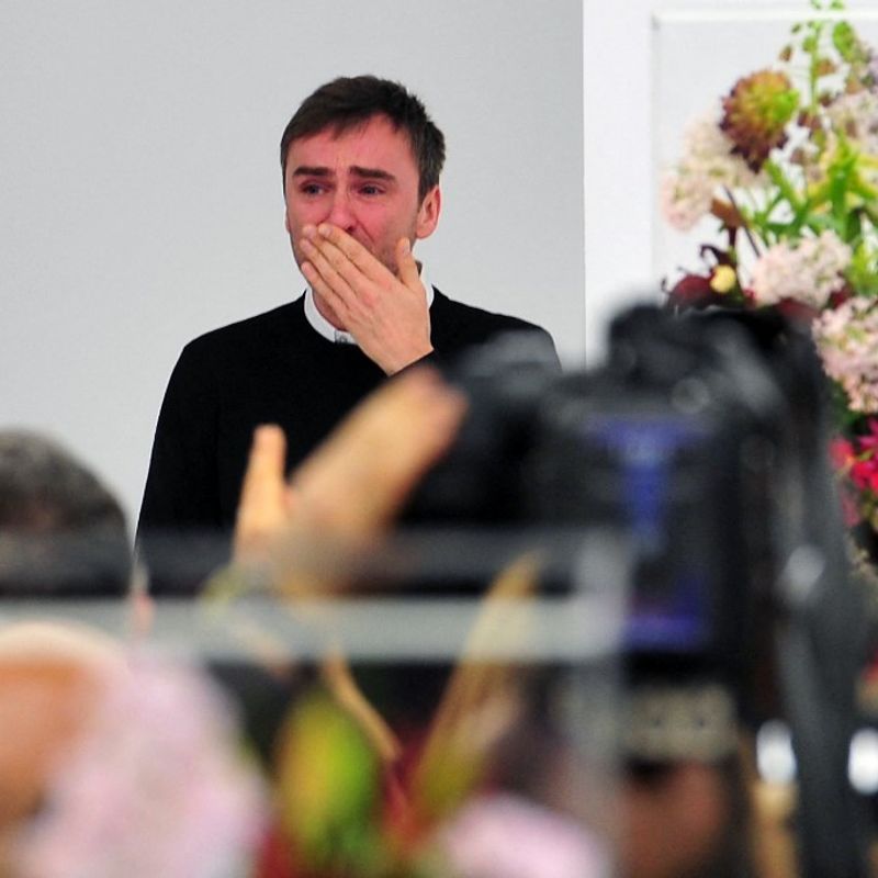 Belgian designer Raf Simons blows a kiss to the audience as he cries at the end of the Jil Sander Fall-winter 2012-2013 collection on February 25, 2012 during the Women's fashion week in Milan. The company announced the day before German fashion designer Jil Sander is set to make a return to the company that bears her name nearly eight years after resigning, with Simons leaving his position of creative director on February 27.  AFP PHOTO / GIUSEPPE CACACE (Photo by GIUSEPPE CACACE / AFP)