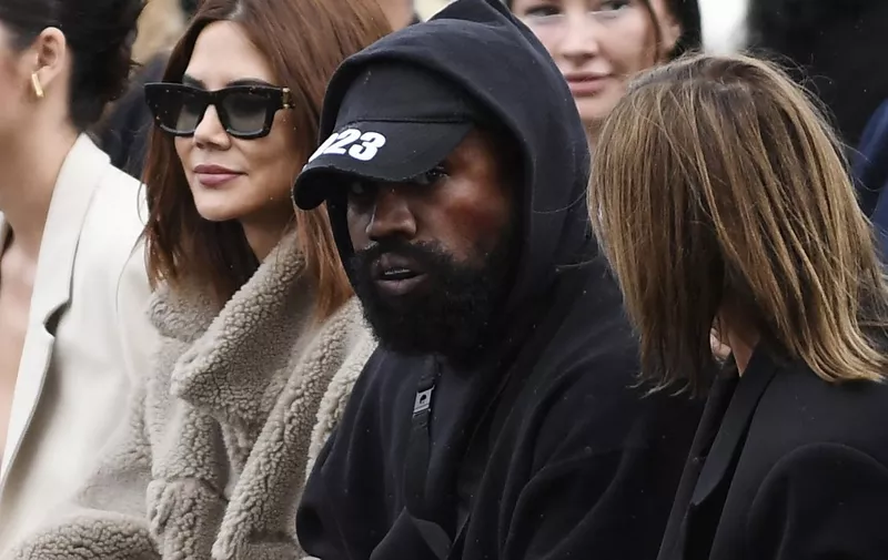 (FILES) In this file photo taken on October 02, 2022 US rapper Kanye West (C), attends the Givenchy Spring-Summer 2023 fashion show during the Paris Womenswear Fashion Week, in Paris. - Social network Parler announced October 17, 2022 a deal for Kanye West to buy the platform popular with US conservatives, just over a week after the rapper's Twitter and Instagram accounts were restricted over anti-Semitic posts. (Photo by JULIEN DE ROSA / AFP)