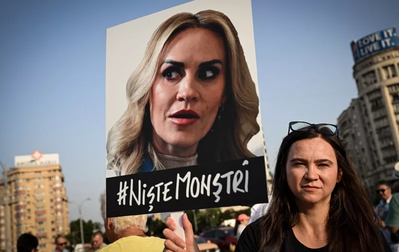 A protester hold a sign depicting Romanian Minister of the Family, Gabriela Firea reading "# Some Monsters" during a protest the ruling parties coalition, in the front of the Romanian government headquarters in Bucharest, on July 13, 2023. Last week anti-organised crime prosecutors (DIICOT) searched 31 locations as part of a probe into the exploitation and mistreatment of elderly and disabled people. The most shocking revelations came from three private-owned care centres on the outskirts of the capital Bucharest, where prosecutors found "two organised crime groups" which "exploited vulnerable people through inhumane or degrading treatment". Around 100 people were found beaten, unfed and lacking medication, DIICOT said, describing torture-like conditions. Romania's minister of labour and social protection Marius Budai resigned on Thursday after an investigation into several homes for the elderly revealed "inhumane treatment" and sent shockwaves through Romanian society. (Photo by Daniel MIHAILESCU / AFP)