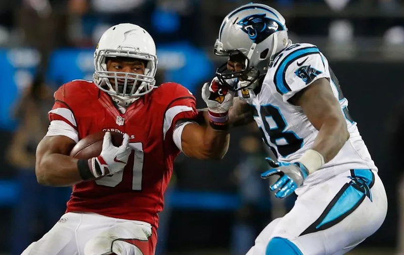 CHARLOTTE, NC - JANUARY 24: David Johnson #31 of the Arizona Cardinals runs with the ball in the first half as Thomas Davis #58 of the Carolina Panthers defends him during the NFC Championship Game at Bank of America Stadium on January 24, 2016 in Charlotte, North Carolina.   Kevin C. Cox/Getty Images/AFP