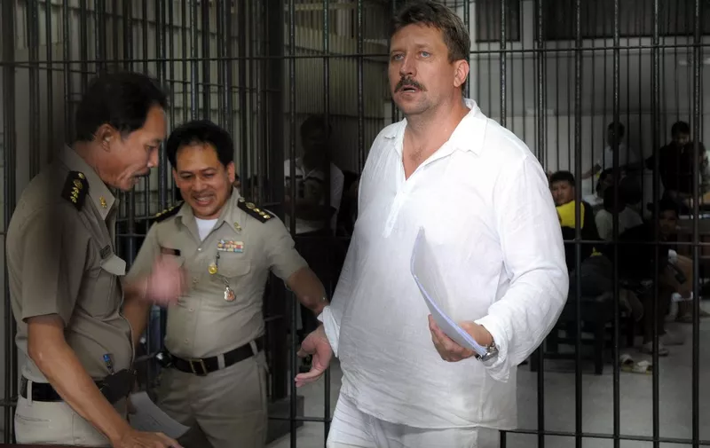 (FILES) In this file photo taken on April 9, 2008 Thai police officers take away Russian arms dealer Viktor Bout after taking his finger prints at the criminal court detention center in Bangkok. - Moscow confirmed on December 8, 2022 it had exchanged US basketball star Brittney Griner, who had been jailed in Russia, for notorious arms trafficker Victor Bout who was serving a 25-year sentence in the United States. (Photo by Saeed KHAN / AFP)