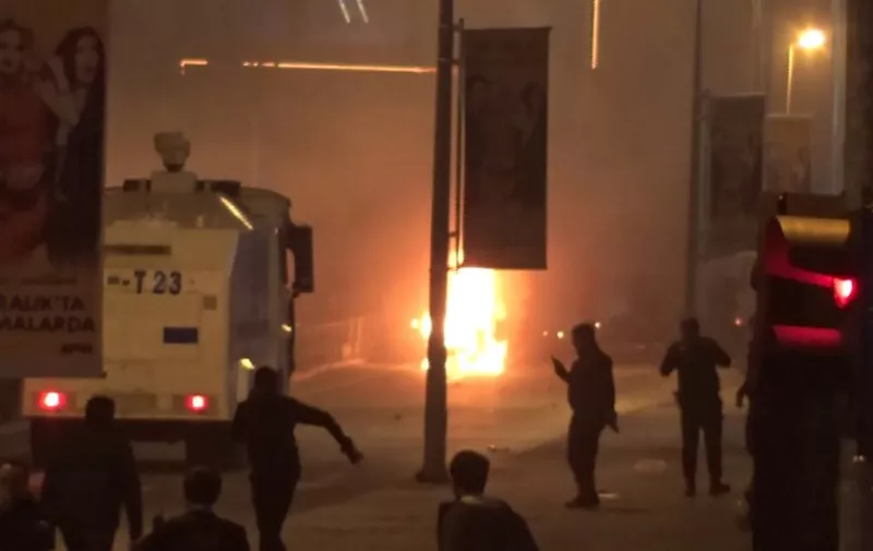 TURKEY OUT
This video grab obtained from Dogan News Agency shows fire and a police car arriving after a car bomb exploded outside the stadium of football club Besiktas in central Istanbul on December 10, 2016.  
The car bomb exploded in the heart of Istanbul on late December 10, wounding around 20 police officers, Turkey's interior minister said, quoted by the official Anadolu news agency. The bomb, apparently targeting a bus carrying police officers, exploded outside the stadium of Istanbul football club Besiktas following its match against Bursaspor.
 / AFP PHOTO / DOGAN NEWS AGENCY / Handout / Turkey OUT