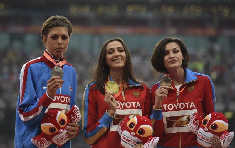 (L-R) Silver medallist Croatia's Blanka Vlasic, gold medallist Russia's Maria Kuchina and bronze medallist Russia's Anna Chicherova celebrate on the podium during the victory ceremony for the women's high jump athletics event at the 2015 IAAF World Championships at the "Bird's Nest" National Stadium in Beijing on August 30, 2015.  AFP PHOTO / GREG BAKER