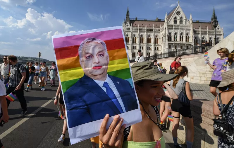 A participant holds up a made-up portrait of Hungary's President Viktor Orban during the LGBTIQA+ Pride Parade in Budapest on July 23, 2022, in memory of the Stonewall Riots, the first big uprising of homosexuals against police assaults in New York City on June 27, 1969. (Photo by Ferenc ISZA / AFP)