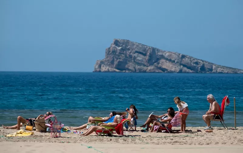 Sunbathers in designated roped-off areas enjoy a day out on Poniente Beach in Benidorm on June 21, 2020, a day after the town's beaches were reopened after three months of closure due to a national lockdown to stop the spread of the novel coronavirus. (Photo by JOSE JORDAN / STR / AFP)