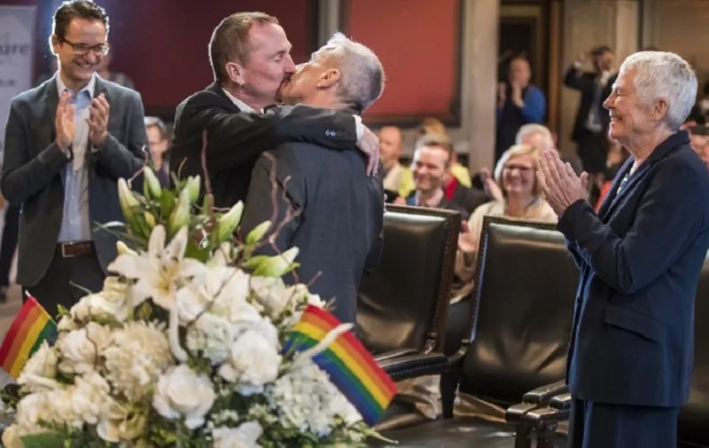 Bode Mende (2nd R) and Karl Kreile (2nd L) kiss watched by their witnesses Angelika Daser (R), Joerg Steinert (L) and guests after becoming Germany's first gay couple to be legally married as they tied the knot at the Schoeneberg town hall in Berlin on October 1, 2017. 
Germany celebrates its first gay marriages as same-sex unions become legal after decades of struggle.
Local authorities rushed to get weddings underway as soon as possible, after lawmakers voted on June 30th to give Germany's roughly 94,000 same-sex couples the right to marry.  / AFP PHOTO / Odd ANDERSEN