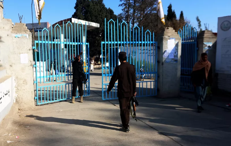 Taliban security personnel stand guard at the entrance gate of a university in Jalalabad on December 21, 2022. - Hundreds of young women were stopped by armed guards on December 21, from entering Afghan university campuses, a day after the nation's Taliban rulers banned them from higher education in another assault on human rights. (Photo by AFP)