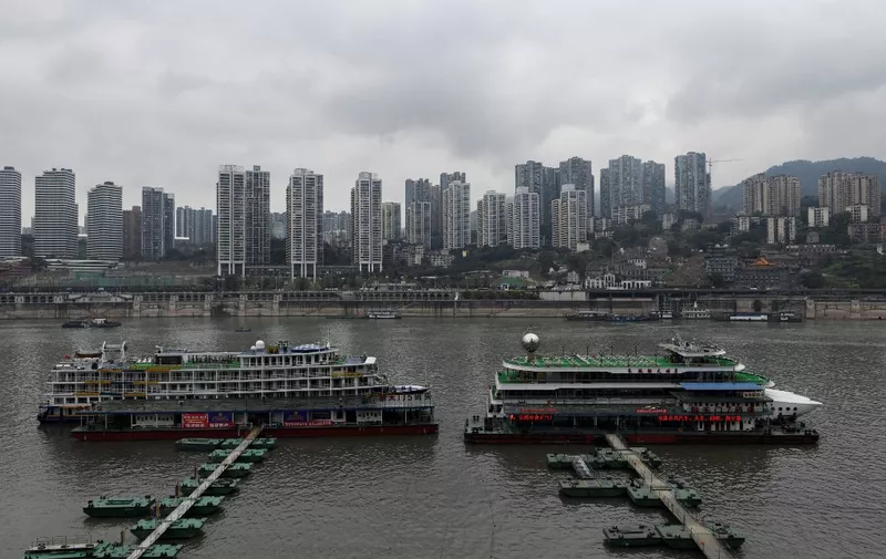 This picture taken on March 22, 2019 shows two cruises docked at a pier in southwest China's Chongqing Municipality. In many Chinese cities, government restrictions have cooled formerly feverish property markets, but in the southwestern city of Chongqing, construction is booming and sales soaring as investors rush in. (Photo by WANG ZHAO / AFP) / TO GO WITH CHINA-PROPERTY-URBAN-PLANNING by Elizabeth LAW