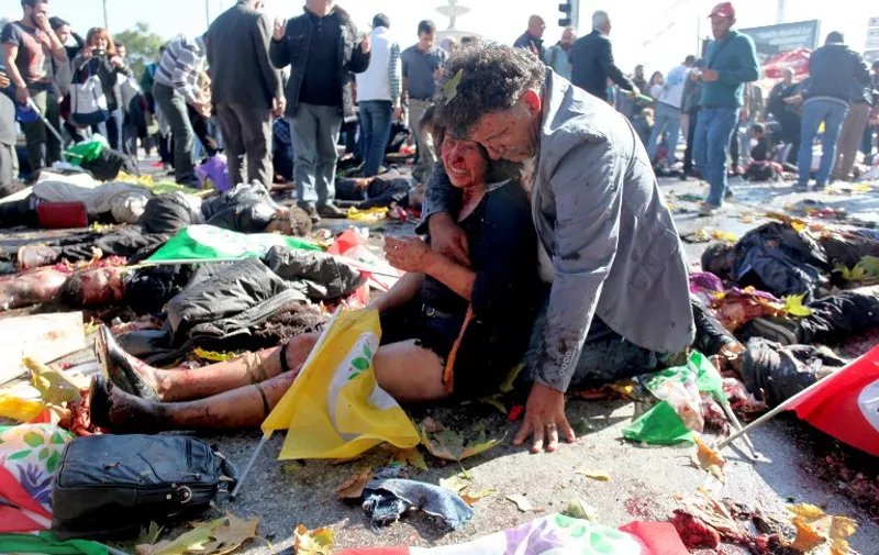 (FILES) - This file picture taken on October 10, 2015 shows an injured woman comforted by a man after an explosion at the main train station in Turkey's capital Ankara. The massive twin bomb attack that killed 102 people was ordered by the jihadist Islamic State (IS) group, prosecutors said on October 28, 2015.    AFP PHOTO / OZCAN YAMAN