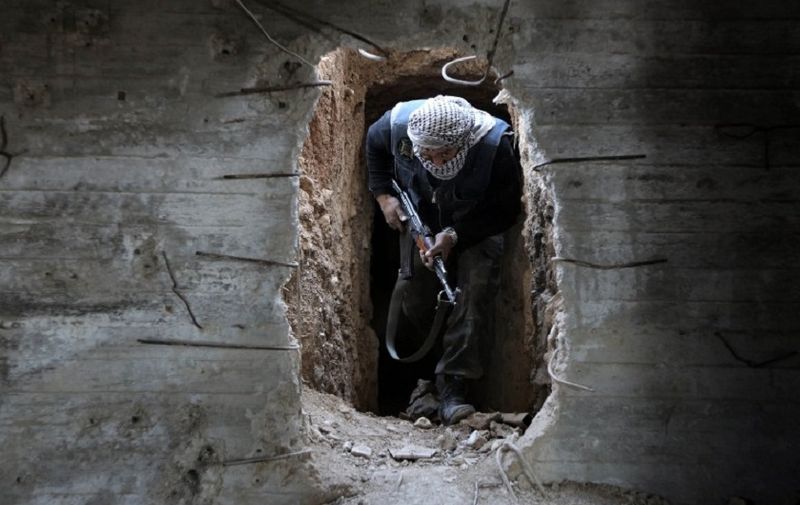 A Syrian rebel fighter from the Failaq al-Rahman brigade comes out of a hiding position on the frontline against regime forces in the town of Arbin in the eastern Ghouta region on the outskirts of the capital Damascus on February 26, 2016. 
A partial ceasefire between Syria's regime forces and non-jihadist rebel fighters is due to take effect at midnight (2200 GMT) local time.
 / AFP PHOTO / AMER ALMOHIBANY