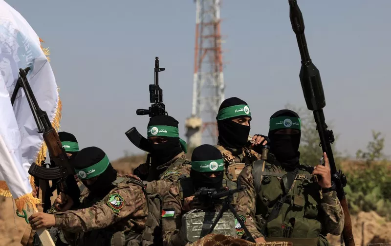 Palestinian fighters of the al-Qassam Brigades, the armed wing of the Hamas movement, take part in a military parade to mark the anniversary of the 2014 war with Israel, near the border in the central Gaza Strip on July 19, 2023. (Photo by MAHMUD HAMS / AFP)