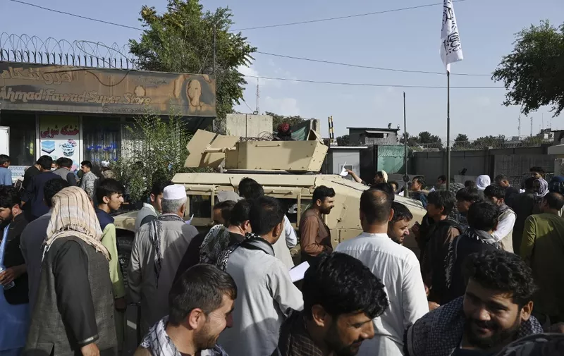 Afghan people wanting to leave the country queue up in front of the British and Canadian embassy in Kabul on August 19, 2021 after Taliban's military takeover of Afghanistan. (Photo by WAKIL KOHSAR / AFP)