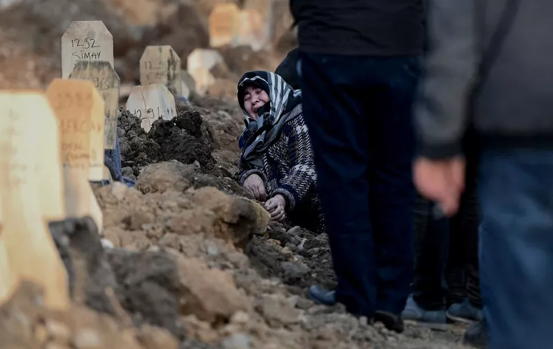 A woman mourns over the grave of her loved ones during a funeral in Kahramanmaras on February 10, 2023, after a 7.8-magnitude earthquake struck the country's southeast earlier in the week. (Photo by OZAN KOSE / AFP)