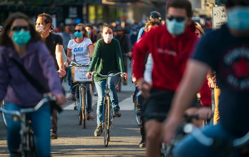 Slovenian citizens wearing protective masks ride their bikes as they block the centre of capital Ljubljana to protest against the centre-right government, accusing it of corruption and of using the novel coronavirus crisis to restrict freedom on May 8, 2020 amid the COVID-19 outbreak, caused by the novel coronavirus. (Photo by Jure Makovec / AFP)