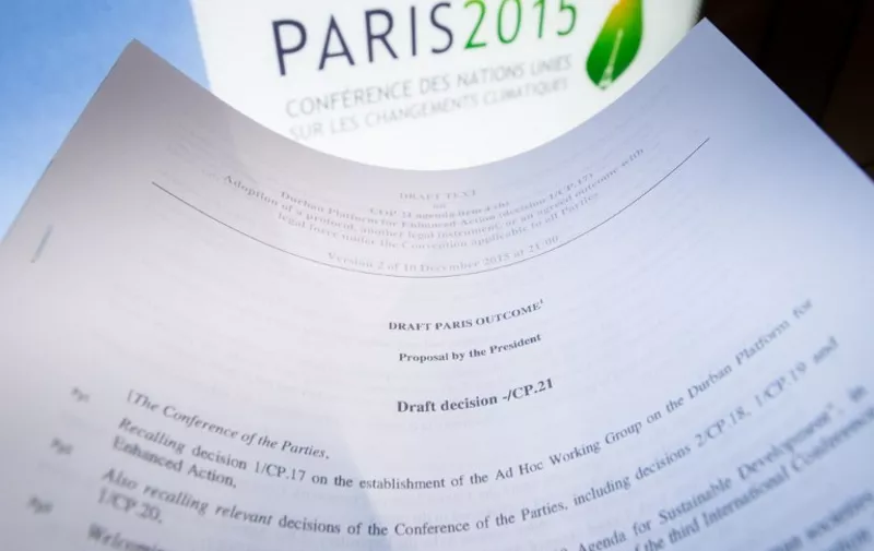 An illustration picture taken on December 10, 2015 in Paris shows a draft for the outcome of the COP21 United Nations conference on climate change next to the logo of the summit.
Sleep-deprived ministers tasked with saving mankind from a climate catastrophe headed into a second night of non-stop talks Thursday, battling to overcome a rich-poor divide in search of a historic accord. Eleven days of UN talks in Paris have failed to achieve agreement on key pillars of the planned post-2020 climate pact, aimed at sparing future generations from worsening drought, flood, storms and rising seas.
 / AFP / Belga / BENOIT DOPPAGNE